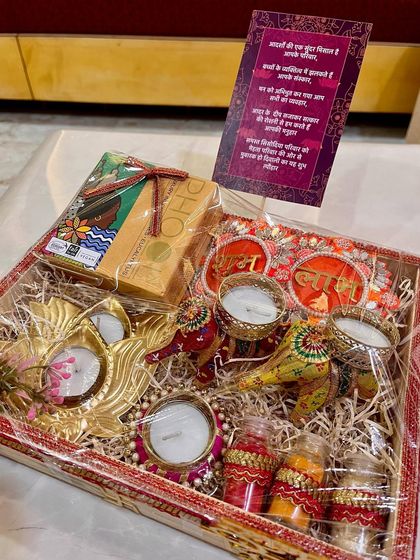 This shagun hamper for the groom's side includes traditional items like diyas, sweets, and roli-chawal, all arranged in a decorative tray with a personalized card. It’s a perfect blend of tradition and modern aesthetics.