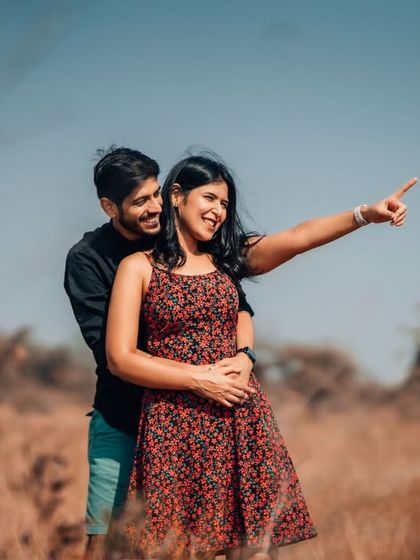 A happy, candid moment during an outdoor photoshoot, where the couple shares a laugh while looking towards their future. We encourage natural interactions to bring out your true personalities.