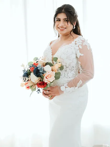 A beautiful portrait of the bride with her bouquet, showcasing her elegant white dress.