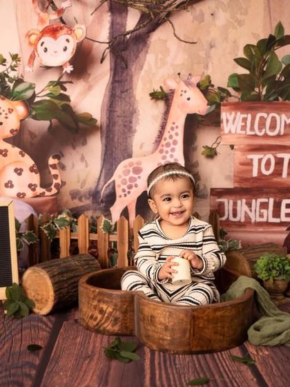A happy smile from the "Wild One". The letter board adds a personalized touch to this adventurous jungle-themed first birthday session.