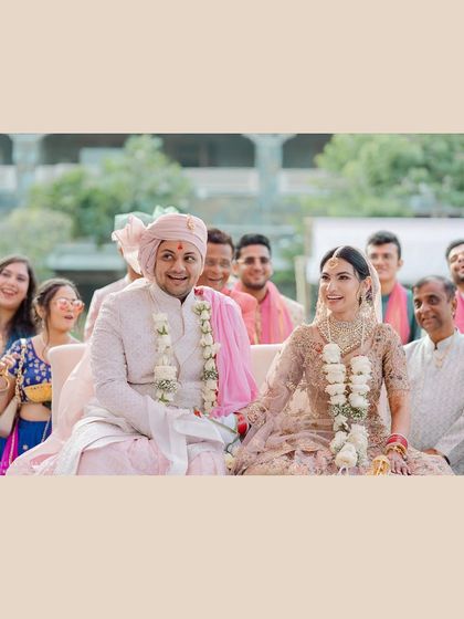 The happy couple, surrounded by their smiling family and friends. A perfect candid shot that captures the collective joy of the moment.