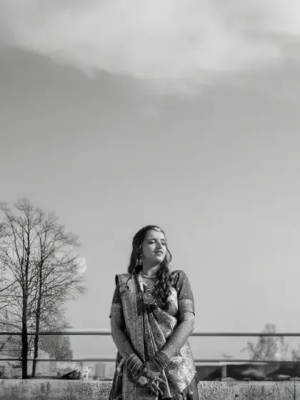 A wide, black and white shot of the bride against an open sky. This creates a feeling of serenity and timelessness, focusing on her solitary beauty.
