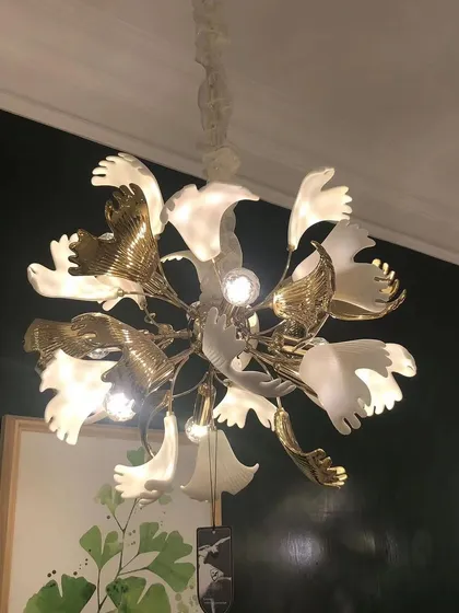 A close-up of a floral chandelier, showing the mix of white and gold petals. This fixture is perfect for adding a touch of elegance and artistry.