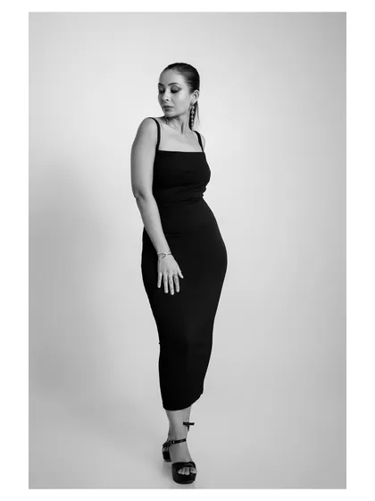 A contemplative pose in the same black dress, again in black and white, creating a moody and artistic feel.