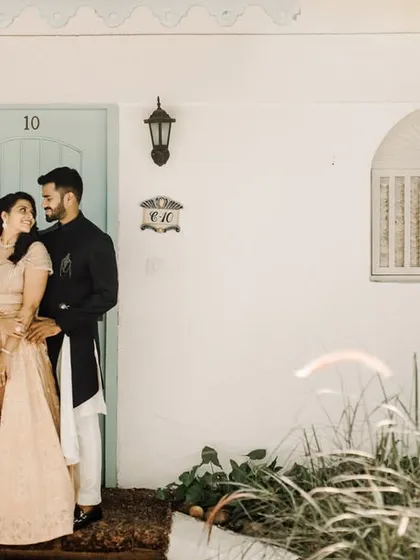 A regal portrait set against the charming architecture of a Goan villa, showcasing the couple's elegant outfits.