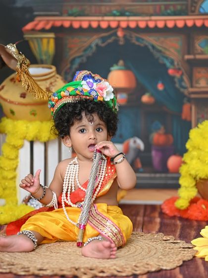 A playful Krishna trying to taste his flute. These candid moments are often the most memorable.