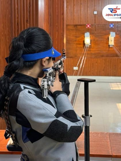 A female shooter demonstrates perfect form, aiming her air rifle at the target. This image captures the essence of focus and precision that we teach in our courses.