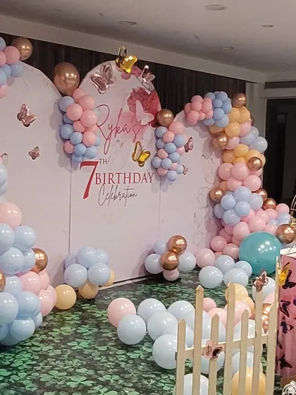 Another angle of the butterfly theme backdrop, showing the arching balloon garland and scattered butterfly decals that create a sense of depth and movement.