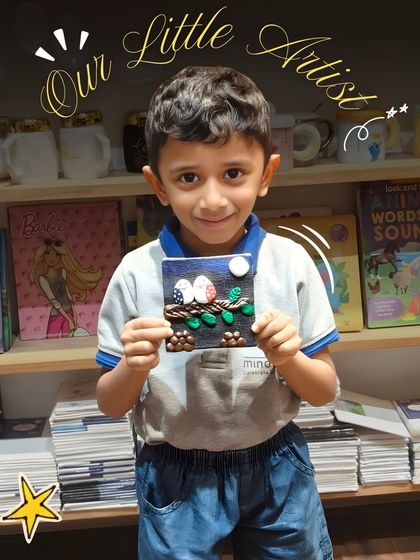 With a star graphic highlighting him as "Our Little Artist," this boy smiles with his finished artwork, a testament to the fun and learning that happens here.