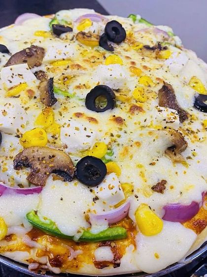 A freshly baked vegetable pizza, perfect for a family dinner or a small party. The crust is soft and the toppings are generous.
