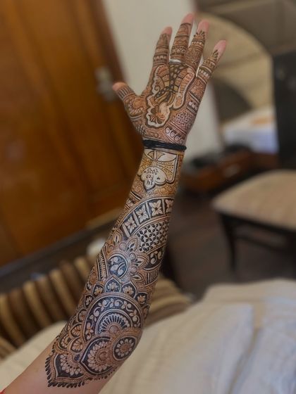 A full-sleeve design with a variety of motifs, including elephants, paisleys, and mandalas, creating a rich tapestry of art.