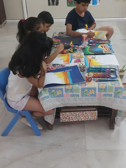 A group of students deeply focused on their paintings. I create a calm and encouraging environment where they can concentrate on their art.