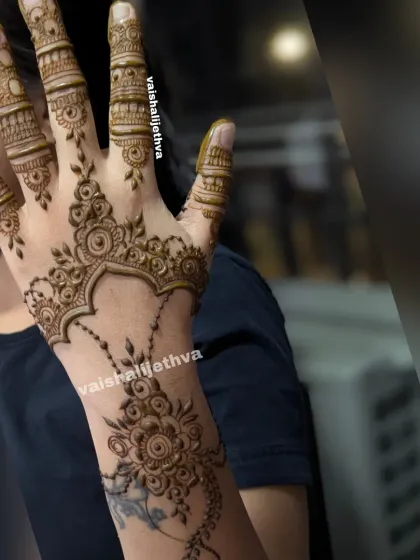 A stylish Arabic fusion design. The pattern flows from the wrist to the finger, combining floral and vine elements.