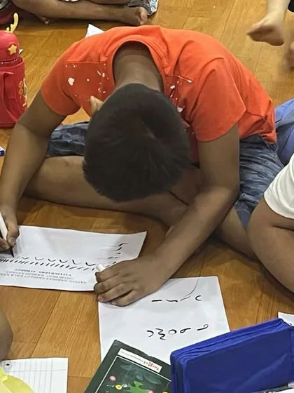 A student deeply engrossed in his calligraphy practice. This activity is excellent for improving concentration and handwriting.