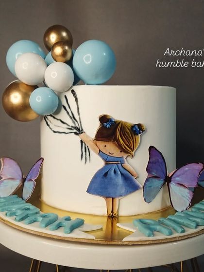 A cute cake with a hand-drawn girl holding balloons, perfect for a little girl's birthday.