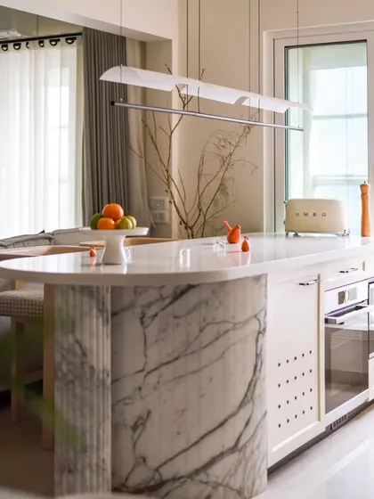 The breakfast counter, with its elegant marble and custom lighting, is a perfect spot for a morning coffee. The design seamlessly integrates with the open-plan living and dining areas.
