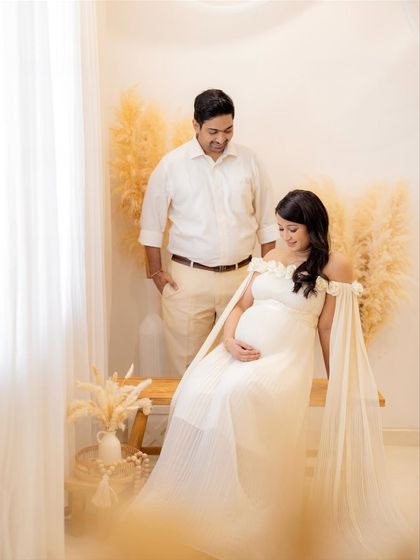 A candid moment of the couple enjoying the photoshoot. The setup includes pampas grass and neutral tones for a modern, bohemian feel.