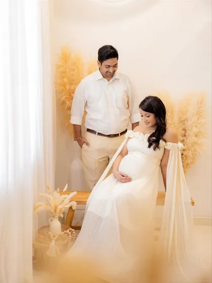 A candid moment of the couple enjoying the photoshoot. The setup includes pampas grass and neutral tones for a modern, bohemian feel.