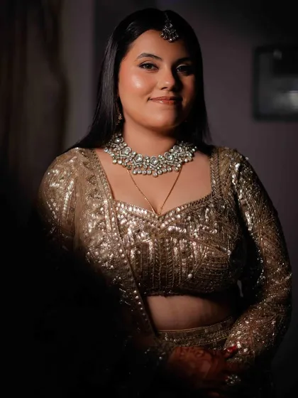 A portrait of pure joy and sparkle. For this bride's reception, we went with a luminous skin finish and soft eyes to complement her dazzling sequined lehenga, letting her happy glow be the centerpiece.