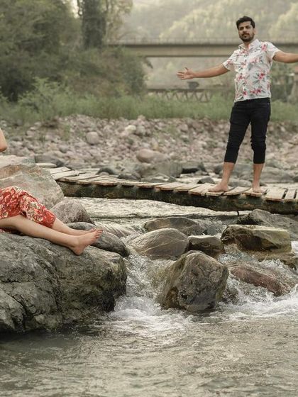 A playful and dynamic shot of the couple by the river, capturing their personalities and the beautiful scenery of their chosen destination.