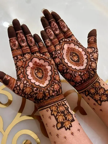 A beautiful mandala design on the palm with delicate floral patterns on the wrist. This is a popular choice for a modern yet traditional feel.