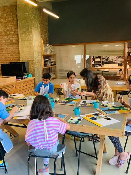 An instructor assists students with their paintings, ensuring they understand the techniques of the post-impressionist master.