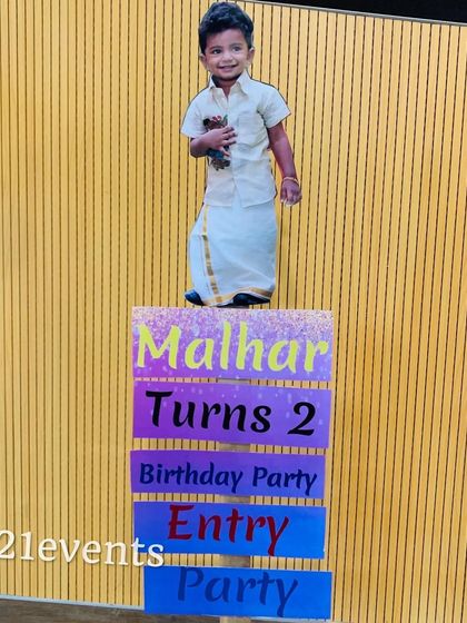 A fun and personalized entry sign for a 2nd birthday party, featuring a cutout of the birthday boy in traditional attire.