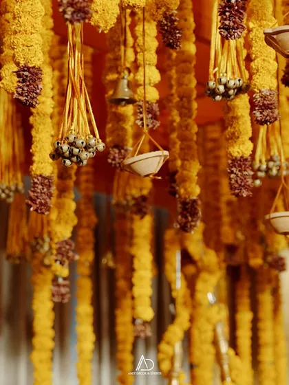 A close-up of the hanging floral decor, featuring strings of marigolds and other traditional elements that add texture and detail to the ceiling.