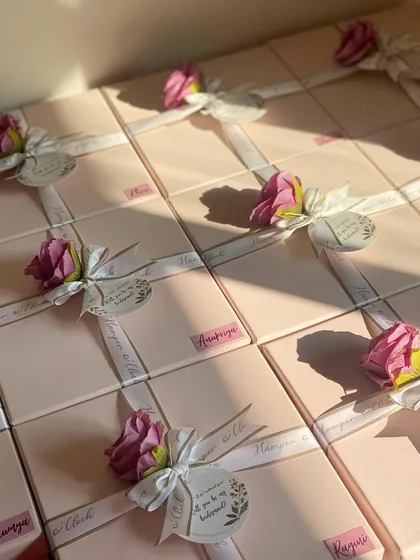 The final look of these pretty pink bridesmaid boxes, all tied up with custom ribbon and a floral touch, waiting to be sent out.