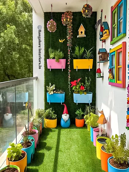 I love bringing a splash of color to a balcony to reflect a client's personality. This project uses a vibrant palette with multi-colored planters and whimsical decor against an artificial green wall. It’s a fun, high-energy design that proves small spaces can have a big impact.