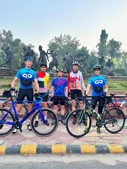 A group of five with their bikes, including two in matching Cookie Monster kits.