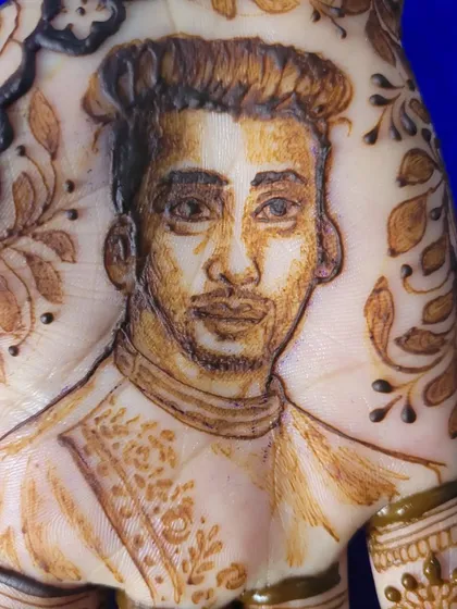 A close-up of the groom's portrait. I focus on getting the likeness just right, capturing his features and expression with fine henna lines and shading.