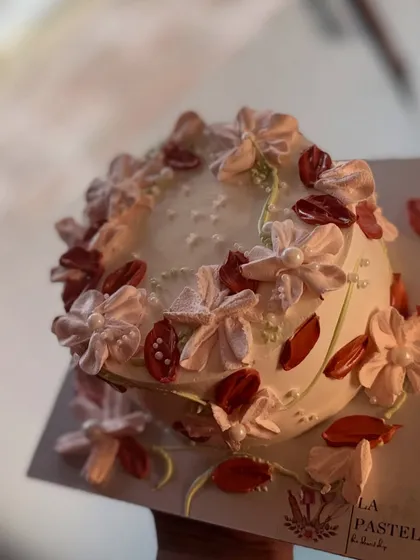 This delicate floral bento cake is decorated with piped flowers and dried petals for a soft, romantic look.