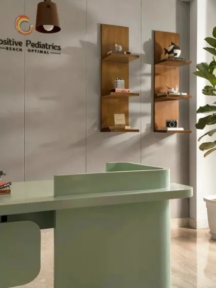 The reception desk was designed with soft, curved edges and finished in a calming mint green to create a welcoming first impression. The wooden display shelves add a touch of warmth and provide space for small, curated objects.