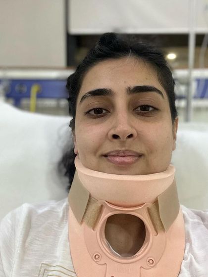 This photo shows our patient in a cervical collar shortly after her neck injury. It provides a stark "before" picture that highlights the incredible progress she made to return to advanced activities like aerial yoga.