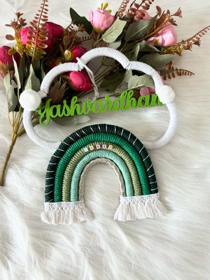 A close-up of a green-themed name hanging for Yashwardhan. You can see the detail in the rainbow wrap and the little name beads I add for that personal touch.