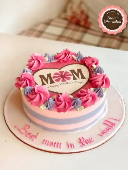 A lovely striped cake for Mother's Day, decorated with pink and purple buttercream roses. The edible print in the center wishes Mom a happy day.