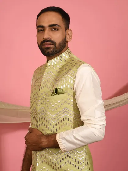 This pistachio green Nehru jacket features a unique geometric foil work embroidery, making it a contemporary choice for a mehendi ceremony or festive gathering. I pair it with a simple ivory kurta to let the jacket's detail shine.
