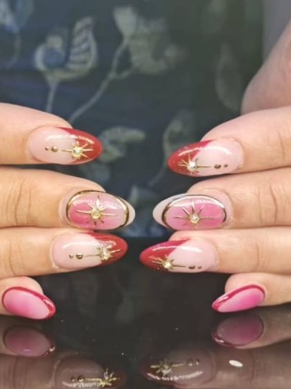 A closer view of the celestial-themed nails, showing the 3D starburst charms and gold details.
