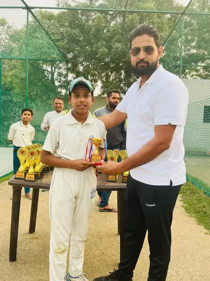 A young player receiving his trophy after a great performance.