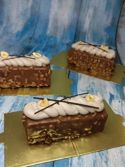 A different angle of the hazelnut mousse pastries, highlighting the piped cream and chocolate decorations.