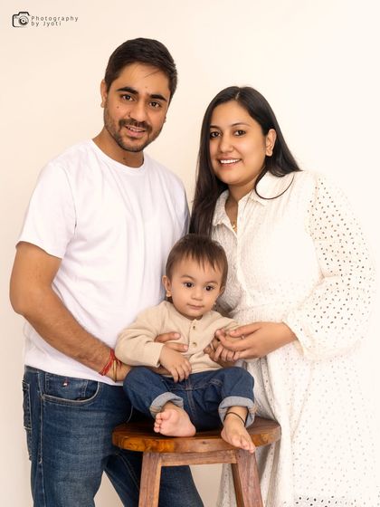 A classic and clean family portrait against a simple white background. The focus here is entirely on the happy expressions and connection of the family.
