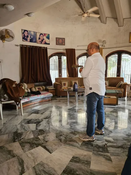 Conducting an energy scan in a client's living room. I use specialized tools to detect subtle energy blockages that can affect the family's well-being.