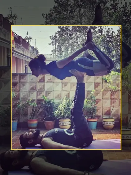 The flyer holds a beautiful Dhanurasana (Bow Pose) while being balanced on the base's feet. This is an advanced acro yoga pose requiring great control.