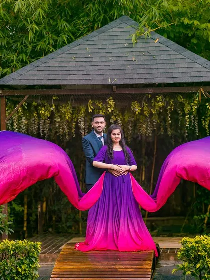 A powerful maternity shot with a flowing purple gown at the garden gazebo.