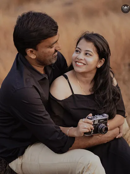 A themed shoot in a field with a vintage camera prop. This is a great idea for couples who share a love for photography or vintage aesthetics.
