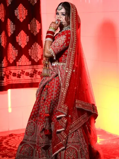 A full-length shot of Shashi, showing off her stunning red lehenga and her confident pose.