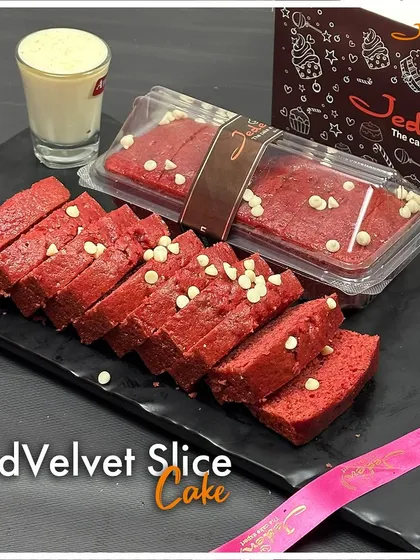 Our Red Velvet Slice Cake offers our signature flavor in a convenient loaf. This vibrant red, moist cake is studded with white chocolate chips, providing a perfect grab-and-go indulgence.