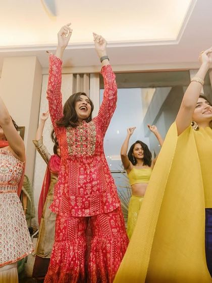 The joy of sharing your most memorable day with your loved ones. A candid shot capturing the pure happiness of the bride and her friends during the Mehendi celebrations.