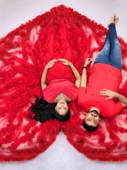 Our signature overhead "sleeping pose" with a couple, featuring a vibrant red ruffled gown arranged in a heart shape.